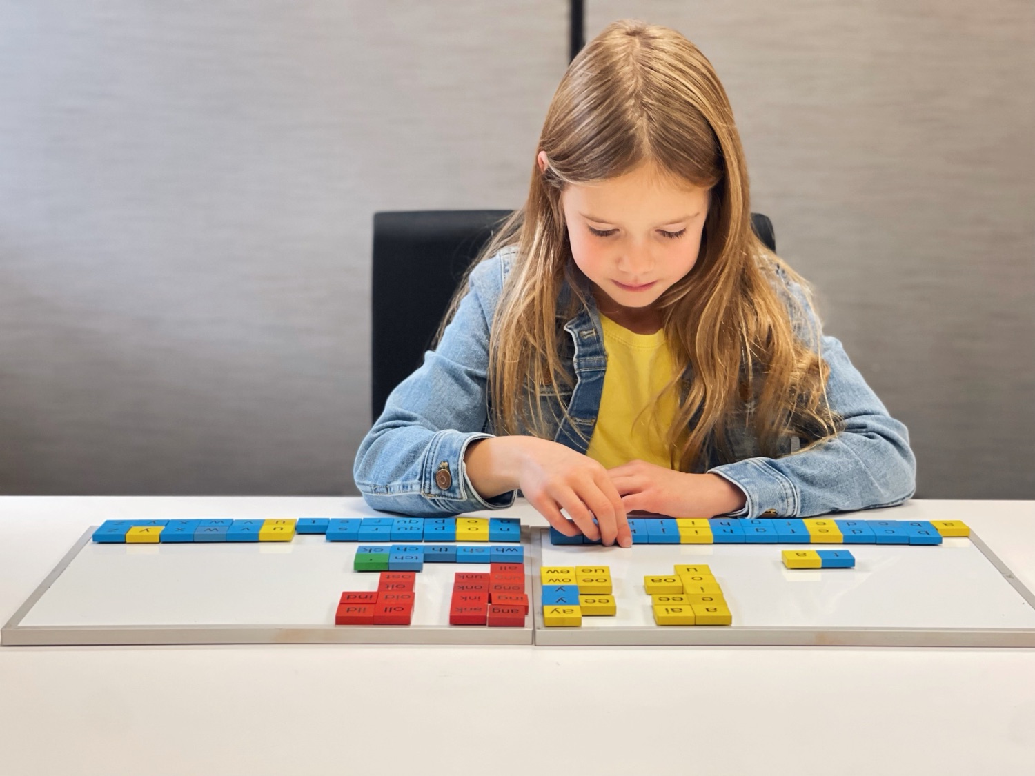 A student building words with color-coded letter tiles during a one-on-one session at Learn to Learn